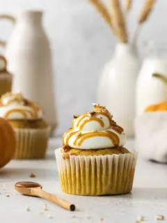 close up photo of a pumpkin cupcake with cream cheese frosting