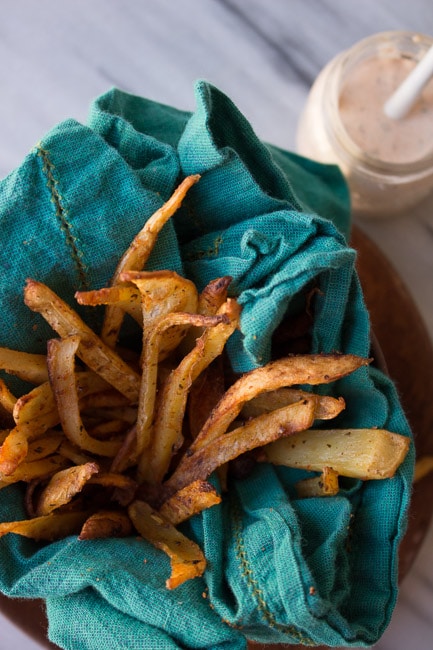oven fries in bowl with bright blue towel
