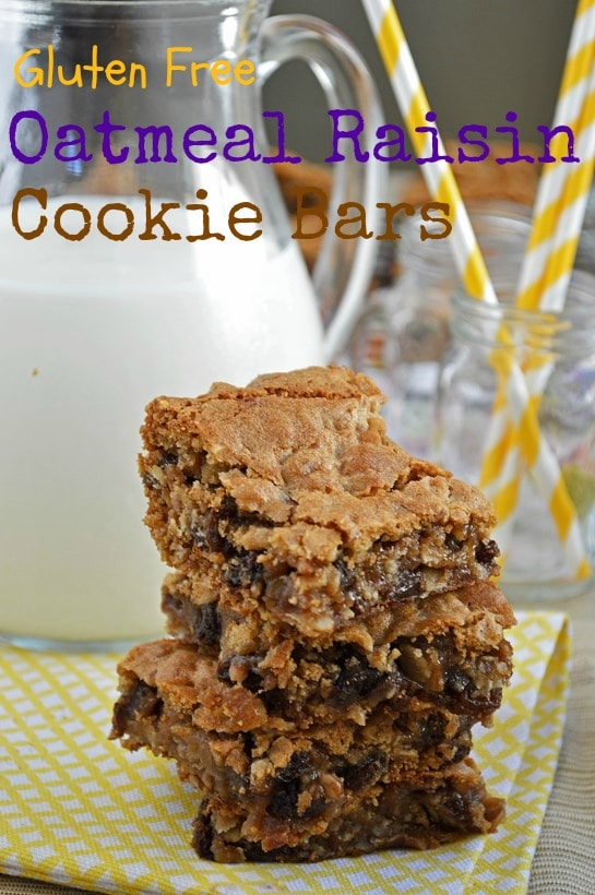 Sliced oatmeal raisin cookie bars on a wire rack and stacked on a napkin. A jar of straws rests in the background. 