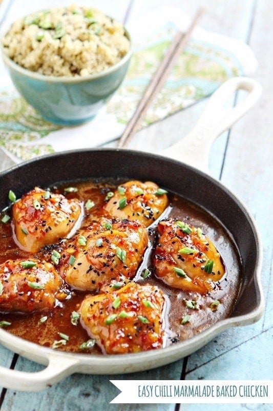 orange marmalade chicken in a cast iron pan next to a bowl of coconut quinoa