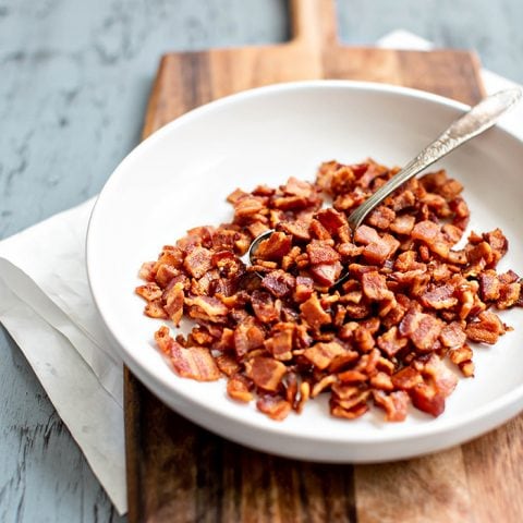 bowl of cooked bacon on cutting board