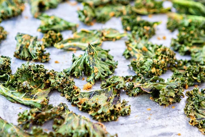 photo of cheesy kale chips on a baking sheet