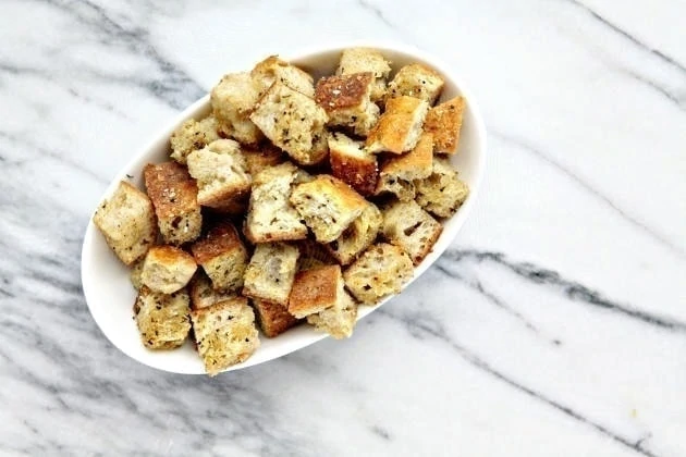 Homemade Croutons in white bowl on marble counter