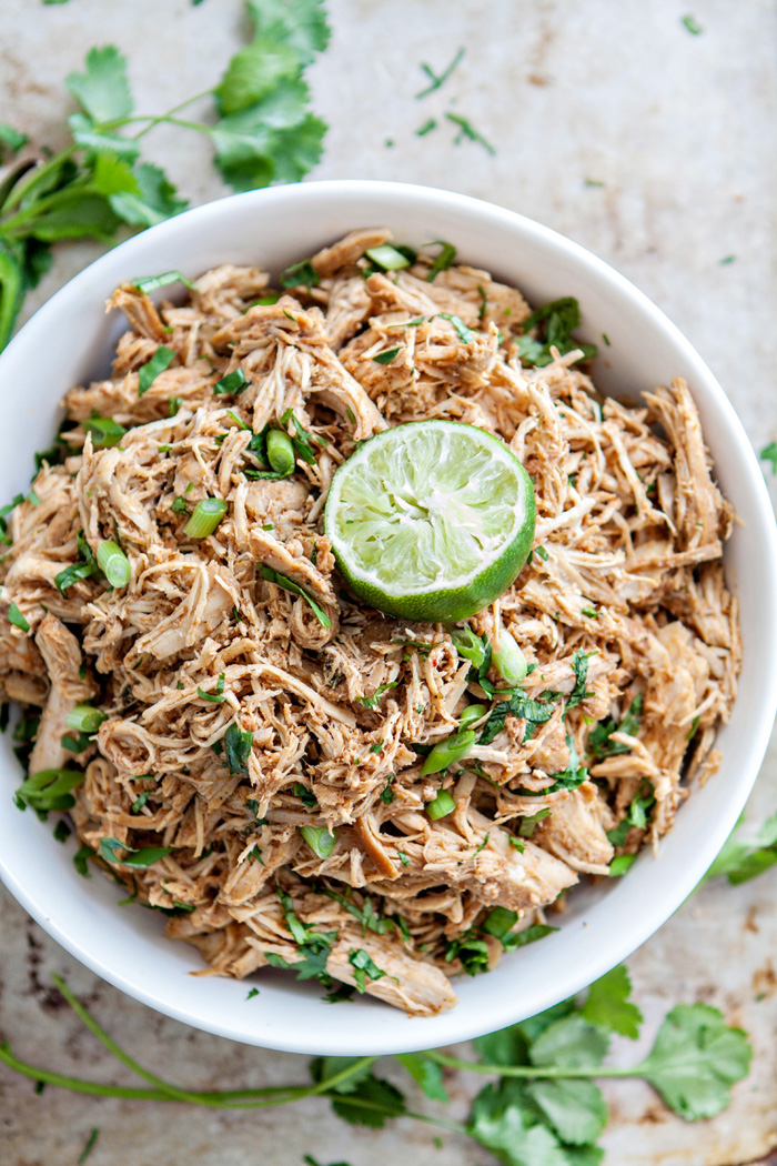 photo of a bowl of shredded chicken with cilantro and lime