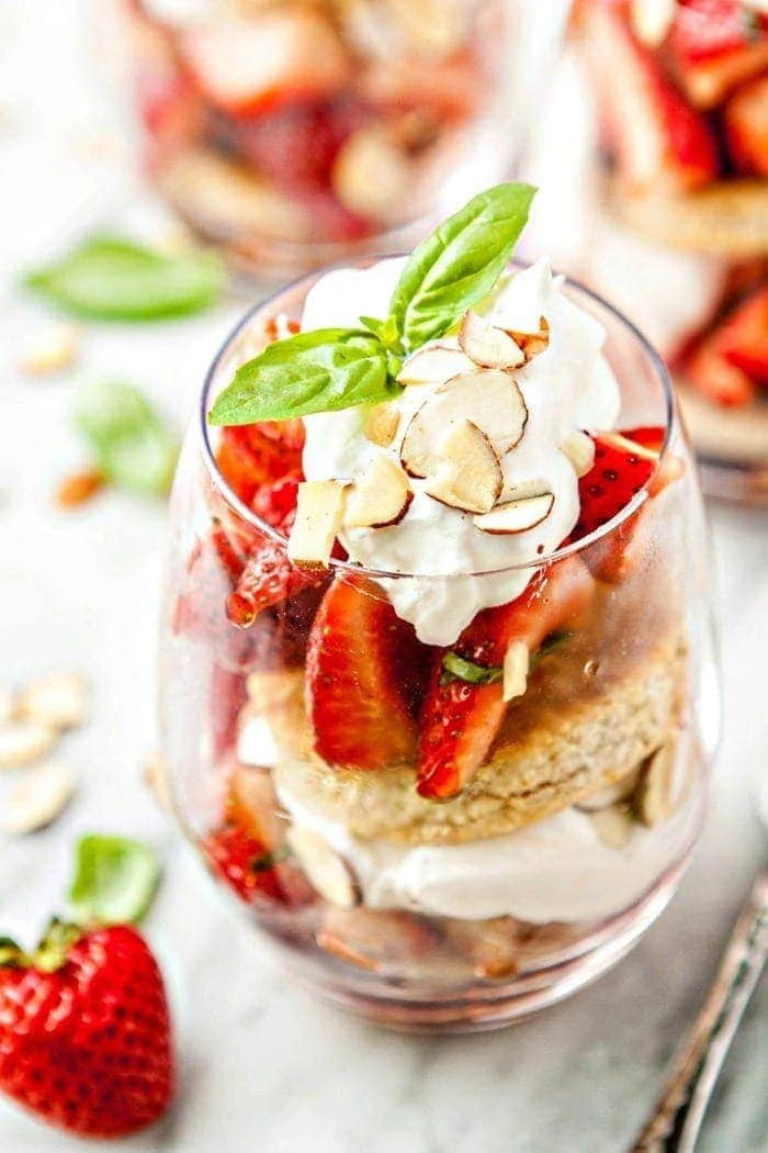 Basil Balsamic Strawberry Shortcake Parfaits in glasses on a white marble counter