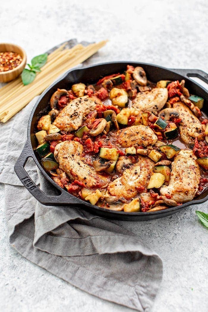 cast iron skillet with italian chicken and tomatoes