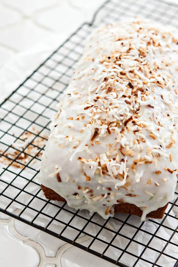 a photo of a loaf of coconut banana bread with toasted coconut on a cooling rack