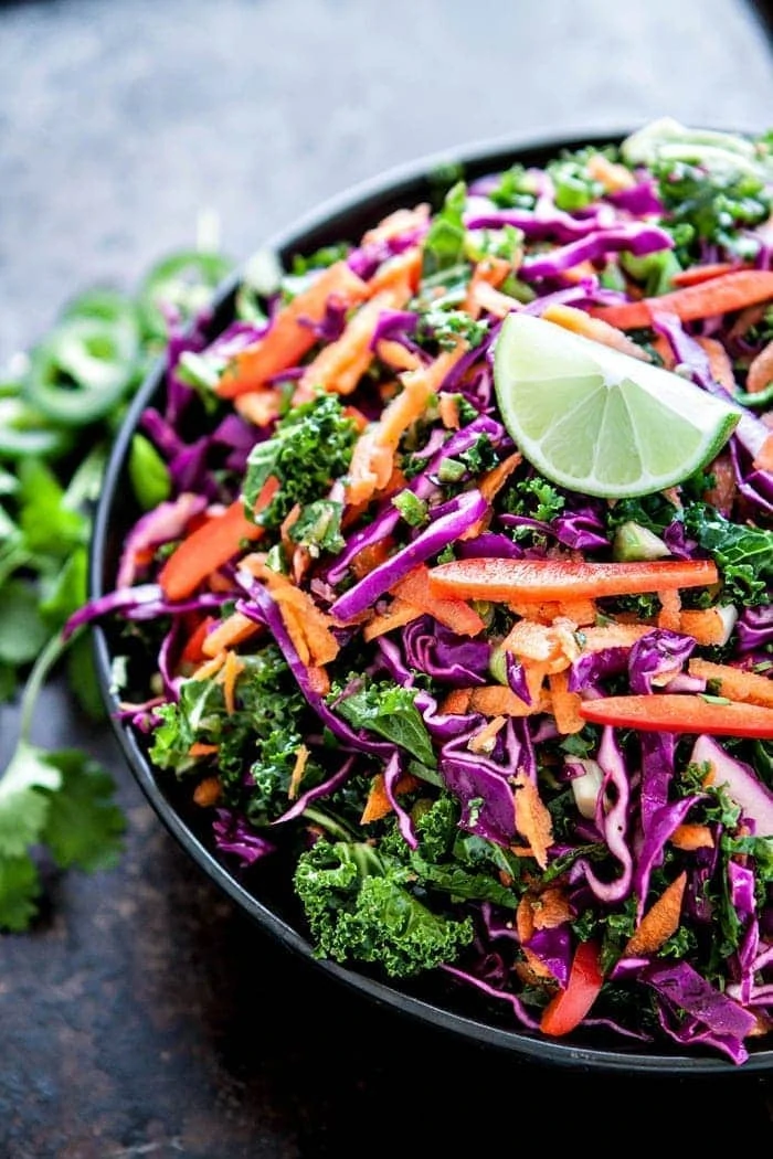Cilantro Lime Kale Slaw in serving bowl garnished with lime wedge