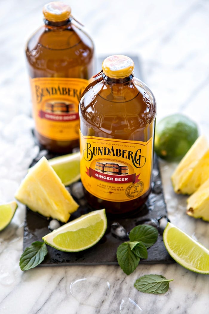 two bottles of bundaberg ginger beer with lime wedges