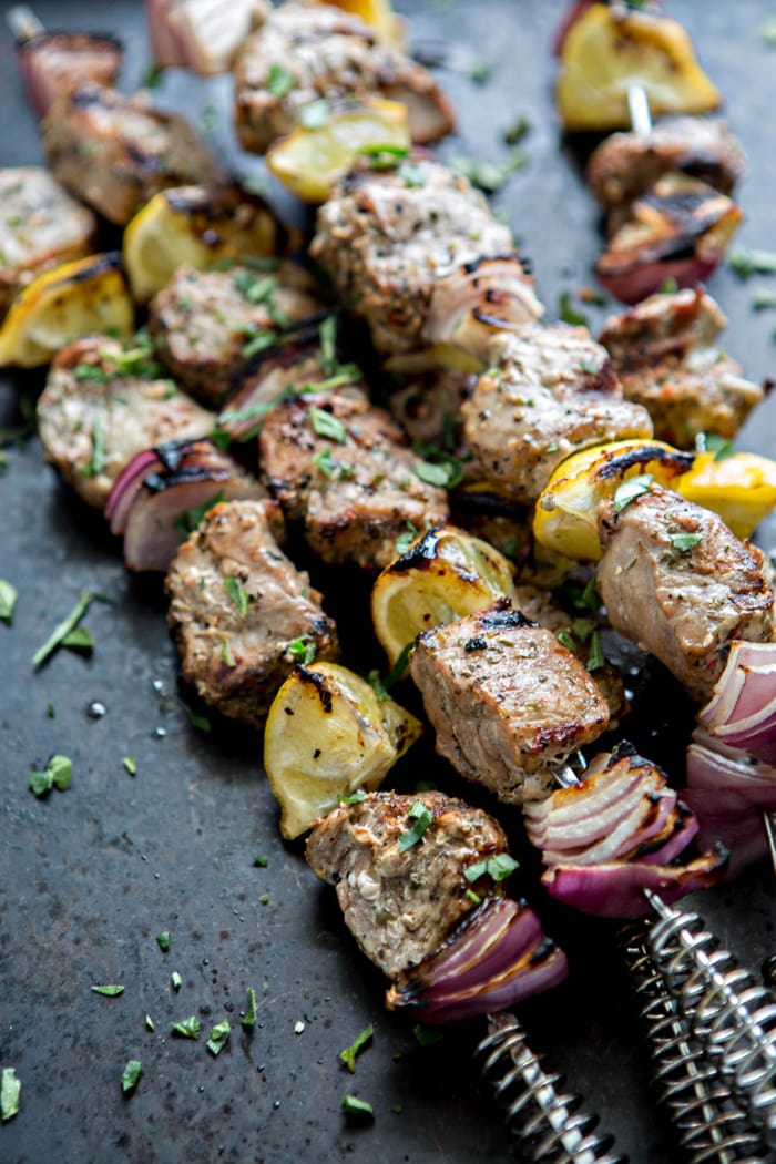 photo of grilled greek pork skewers with lemon and onion to serve on a kebab platter