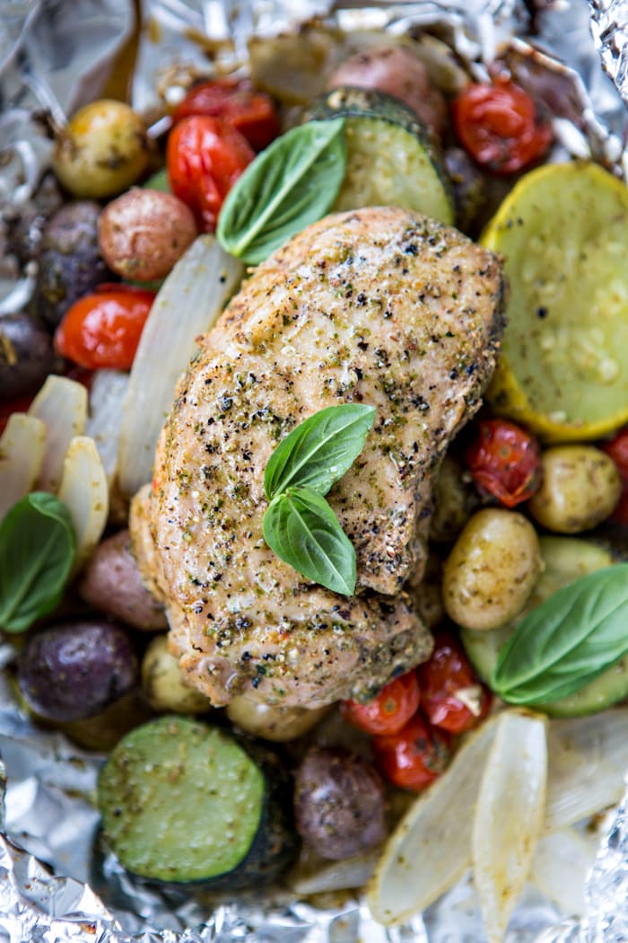 a photo of Pesto Pork Chops with summer vegetables in a foil packet