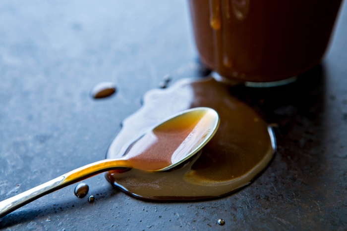 close up photo of a spoon with bourbon caramel sauce