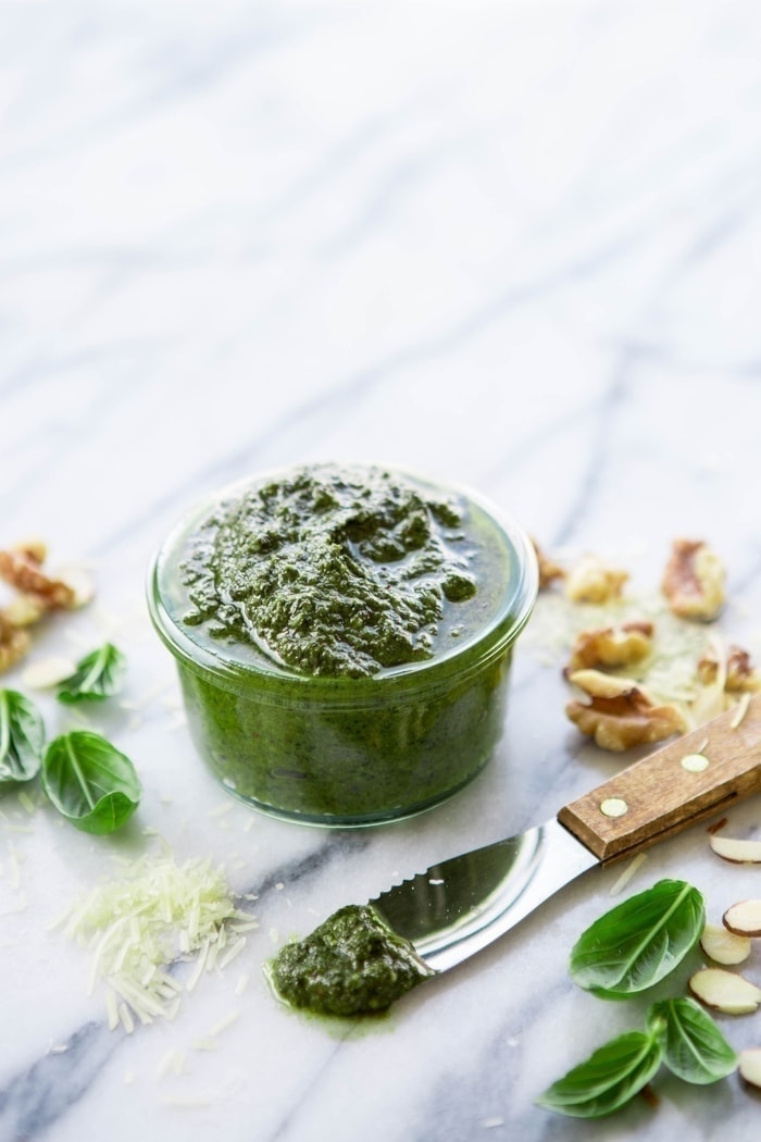jar of fresh pesto on a marble counter top
