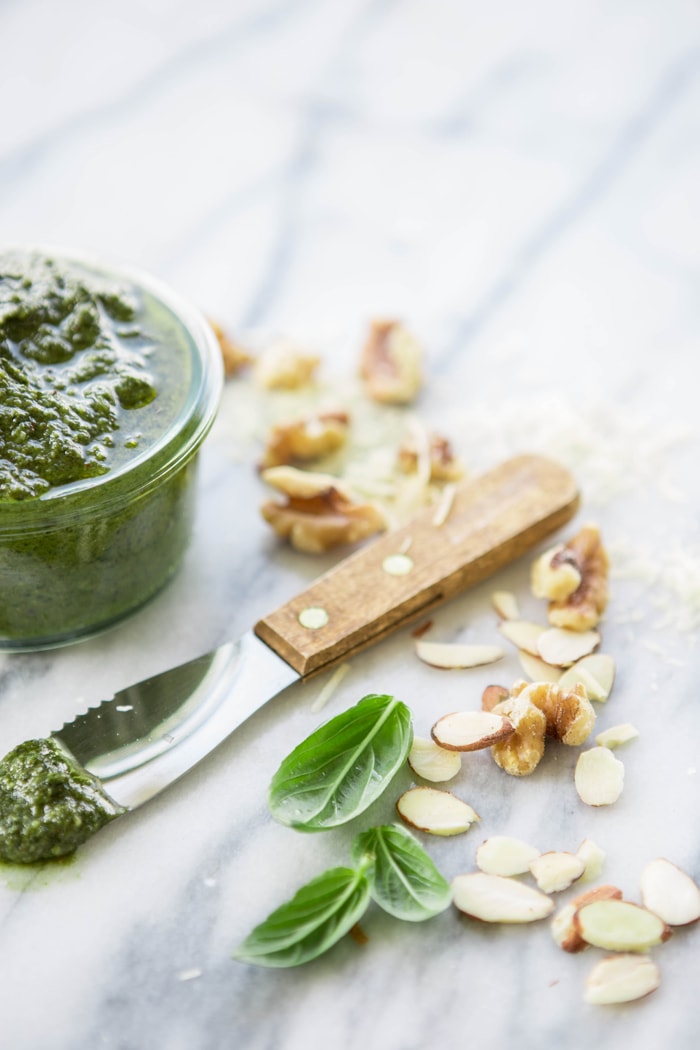 jar of fresh pesto on a marble counter top