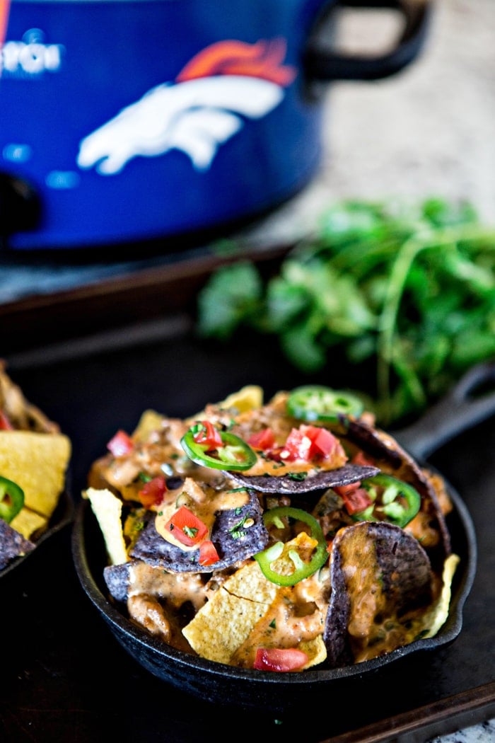 mini skillet filled with tortilla chips and crock pot queso dip