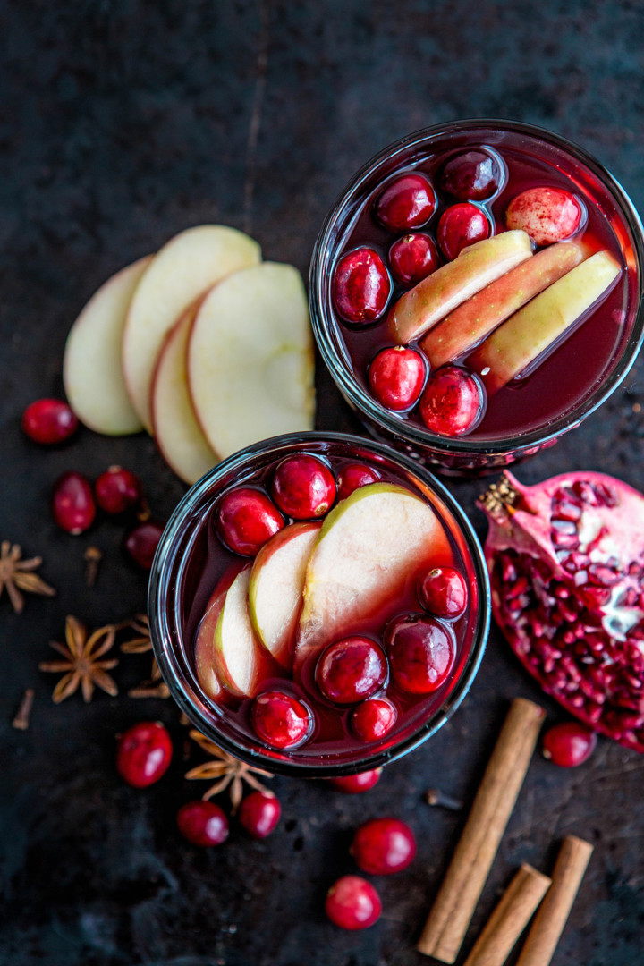 overhead photo of two glasses of spiced wine with fresh fruit