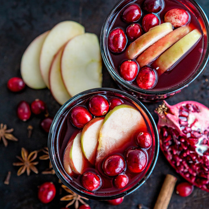 overhead photo of two glasses of spiced wine with fresh fruit