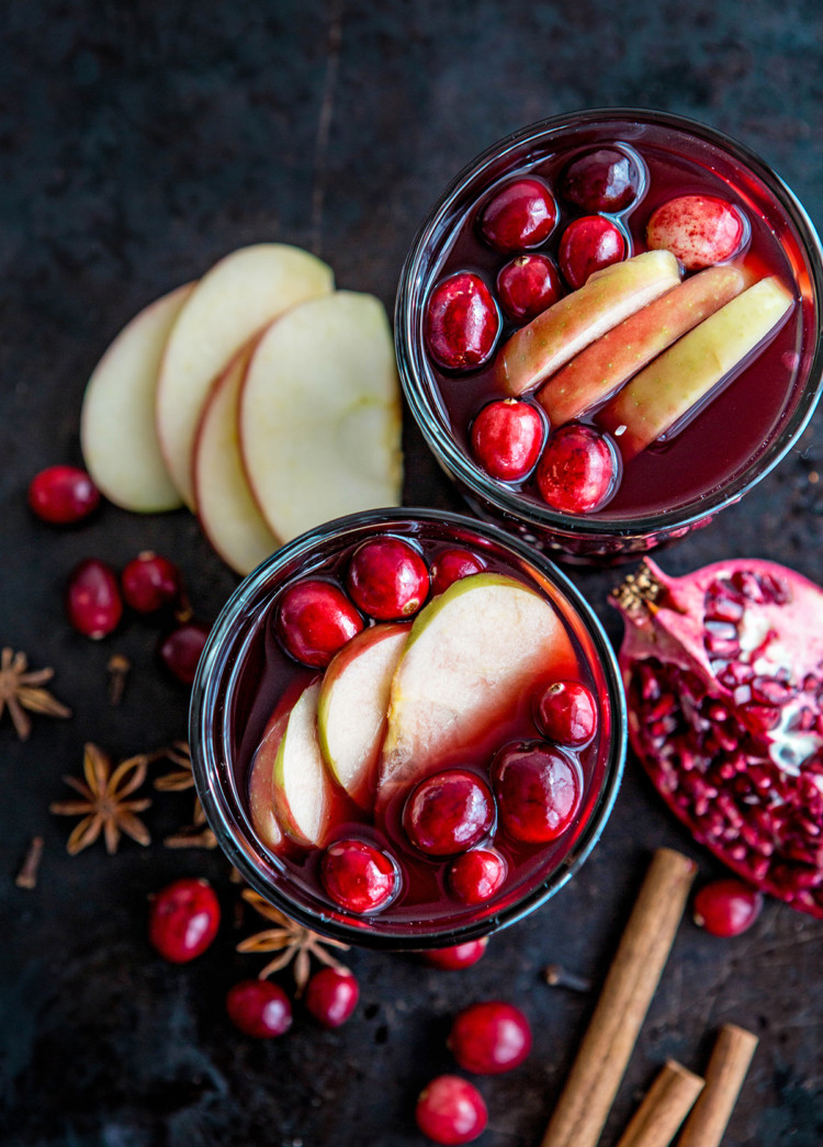 overhead photo of two glasses of spiced wine with fresh fruit