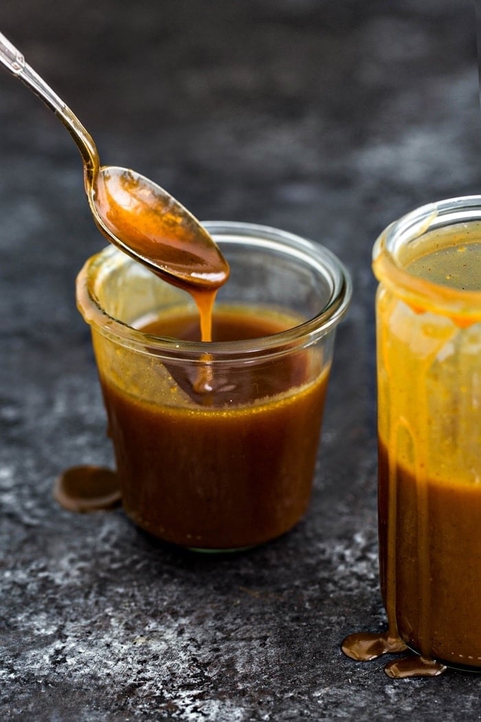 spoonful of salted caramel sauce over glass jar