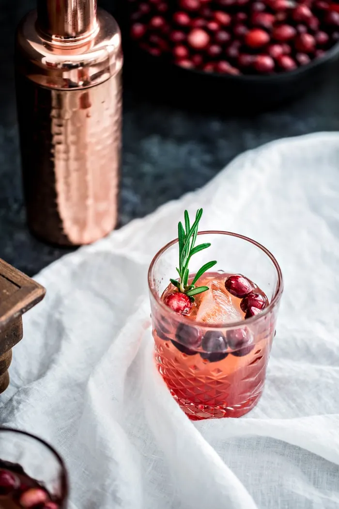 Photo of a cranberry cocktail made with rosemary shrub