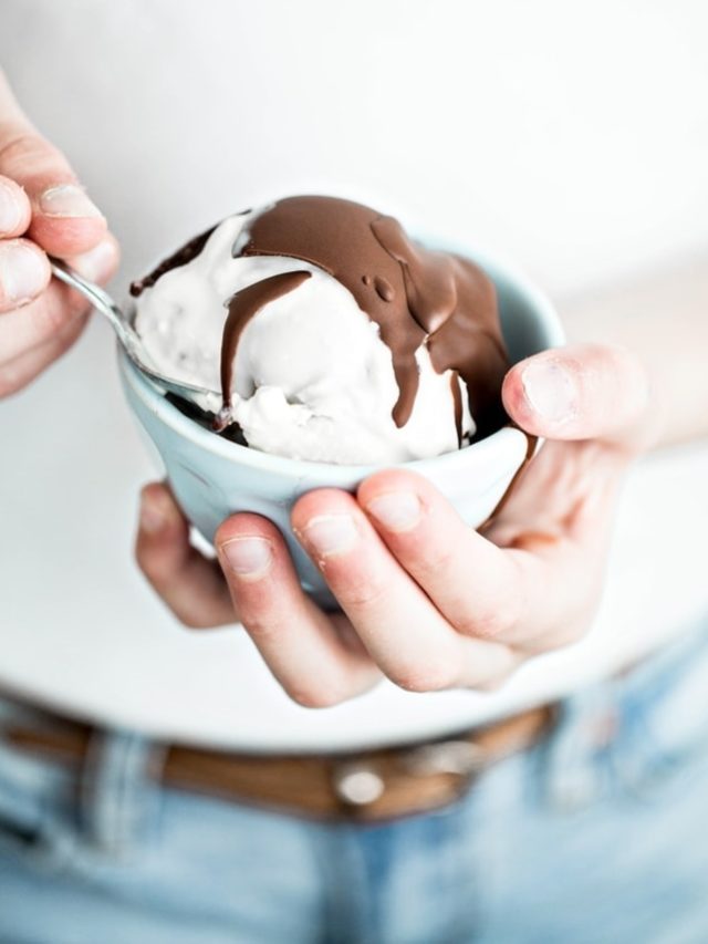 girl holding a bowl of ice cream with chocolate topping