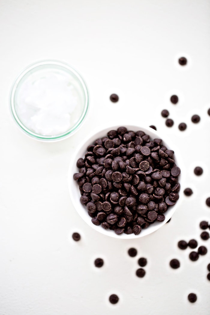 photo of a white bowl of chocolate chips one a white background - ingredients to make homemade magic shell recipe