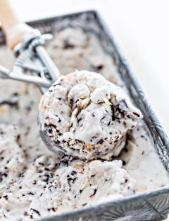 ice cream scoop in an ice cream container with ice cream on white background