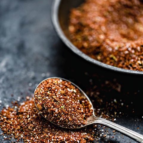 bowl of pork rub with spoon on a dark background