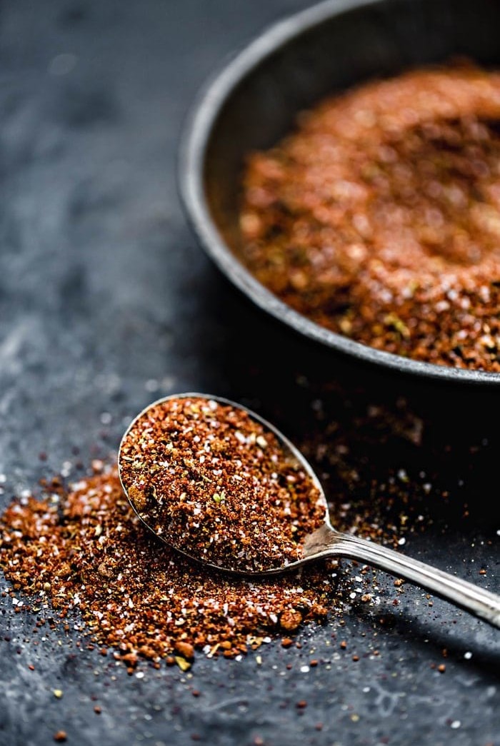 bowl of pork rub with spoon on a dark background