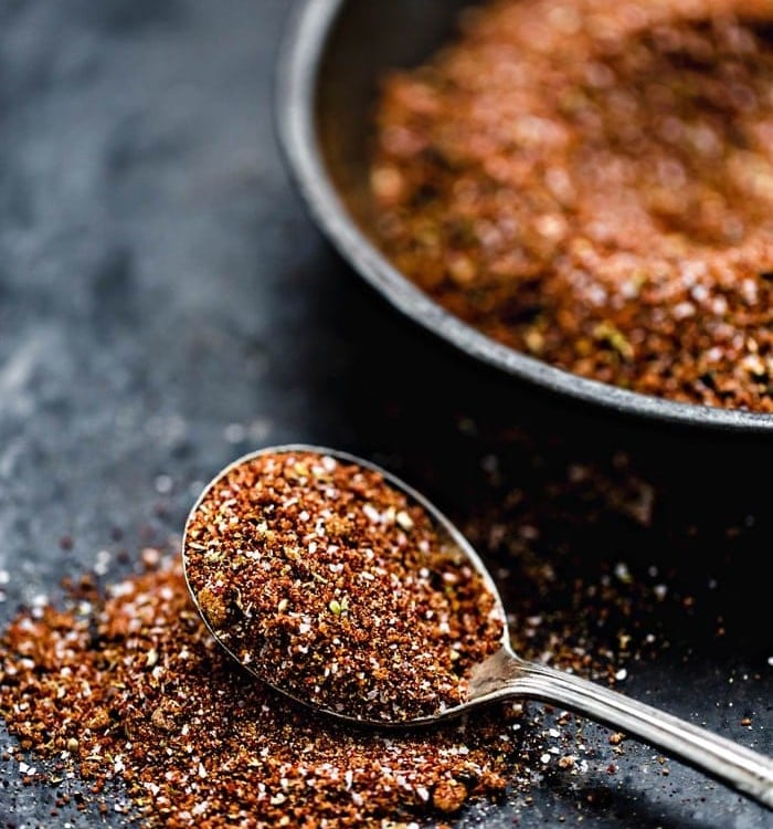 bowl of pork rub with spoon on a dark background