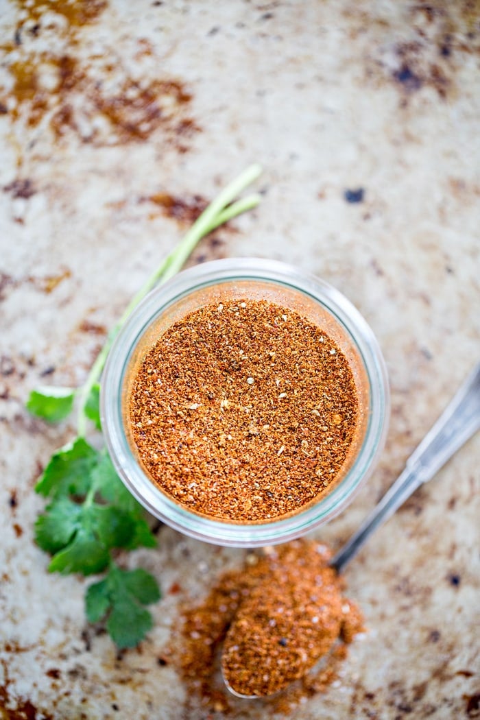 overhead shot of spice jar with spoon and cilantro