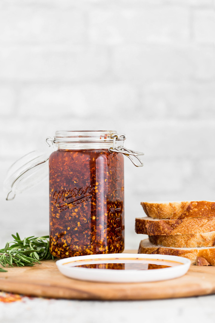 Jar or Chili Garlic Oil and Artisan Bread on a Cutting Board