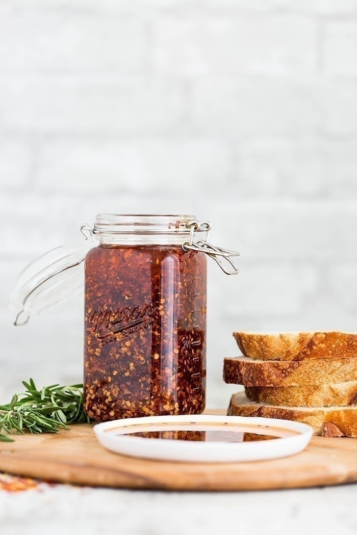 Jar or Chili Oil and Artisan Bread on a Cutting Board