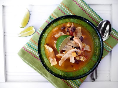 An overhead view of southwest tortilla soup garnished with lime wedges