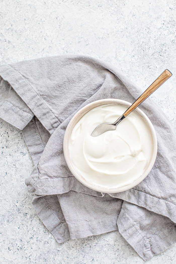 an overhead shot of a bowl of plain yogurt to use for a buttermilk substitute 