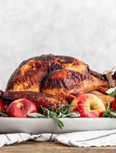 turkey on a platter with apples and sage