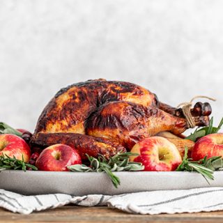 turkey on a platter with apples and sage