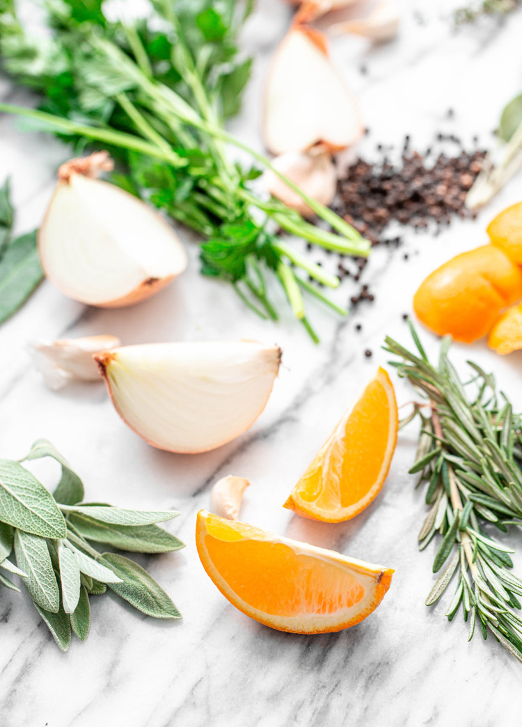 ingredients in citrus turkey brine: orange slices and fresh herbs on white background