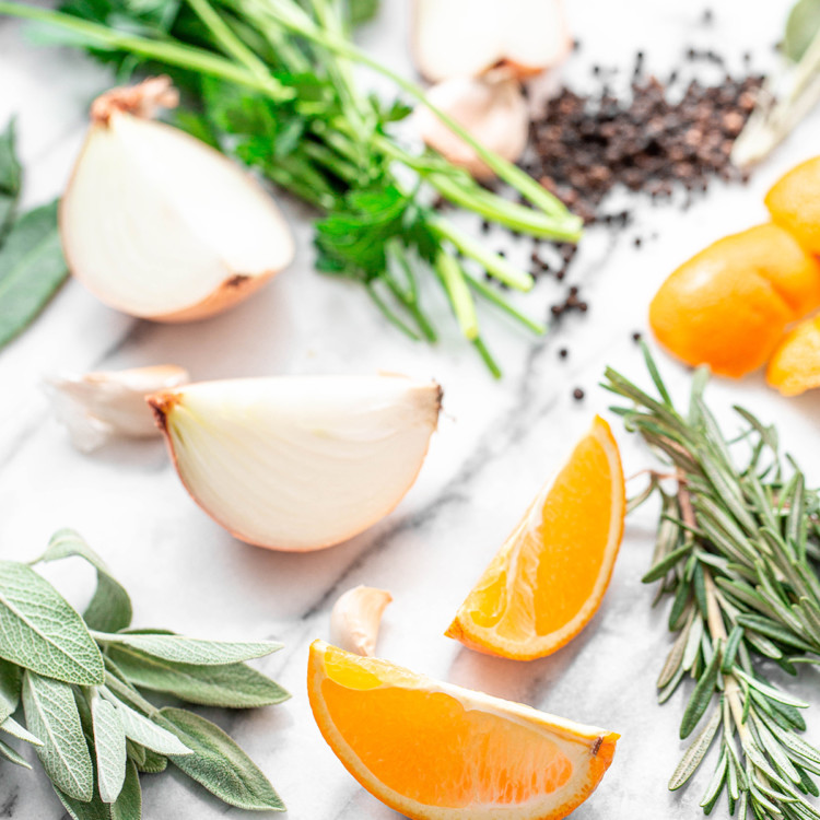 ingredients in citrus turkey brine: orange slices and fresh herbs on white background