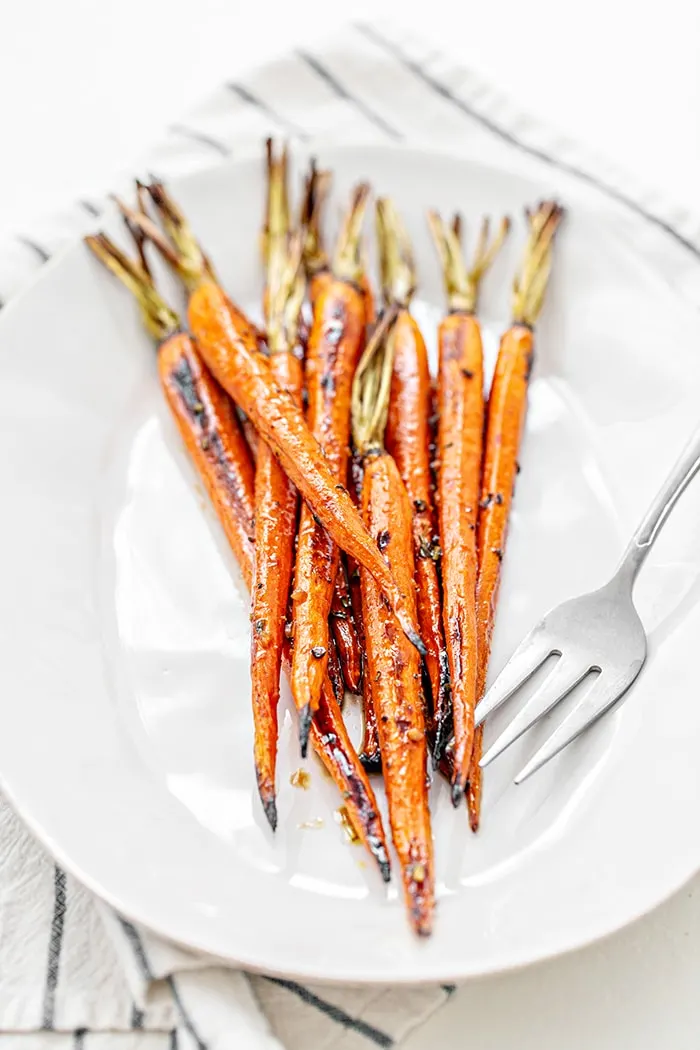 whole balsamic roasted carrots on a white plate