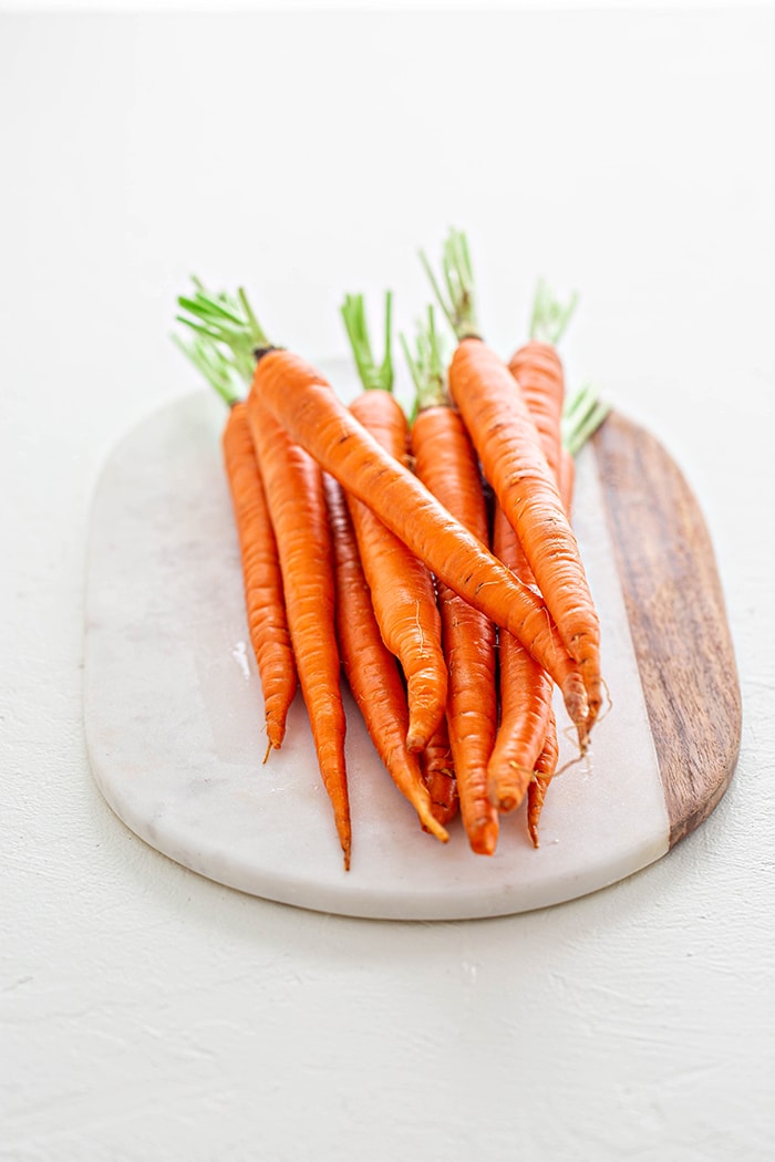 whole carrots on a marble platter