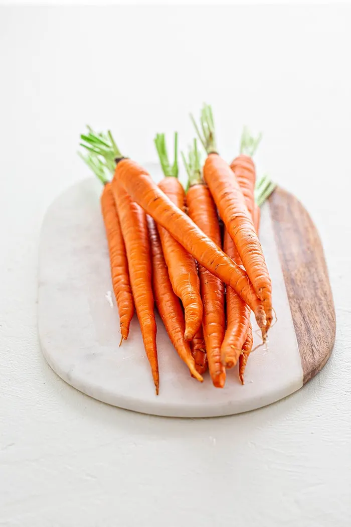 whole carrots on a marble platter