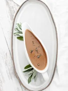 turkey gravy with sage in a white gravy boat