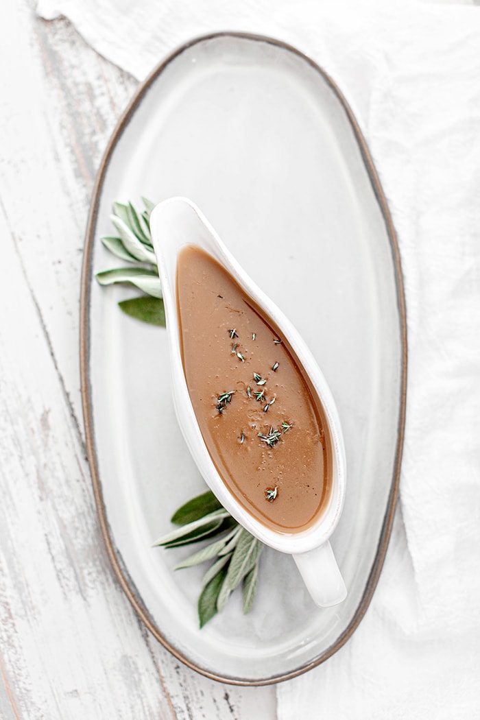 turkey gravy with sage in a white gravy boat