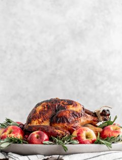 turkey on a platter with apples and sage