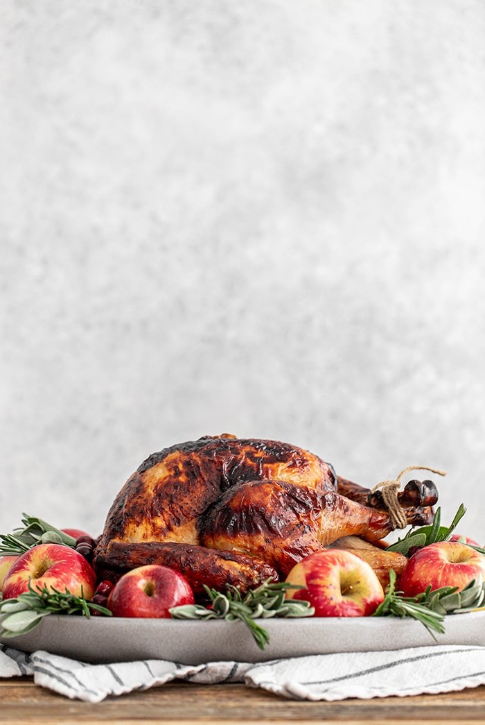 turkey on a platter with apples and sage