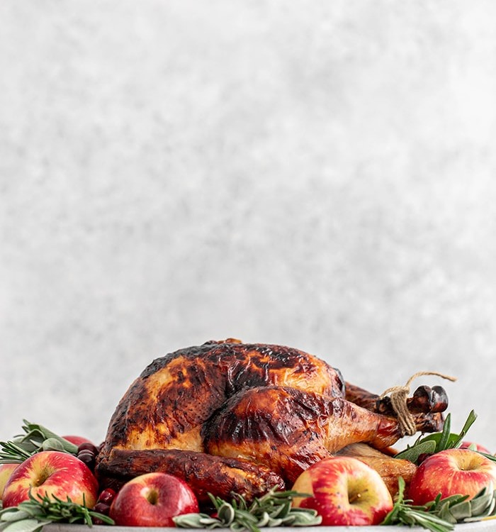 turkey on a platter with apples and sage