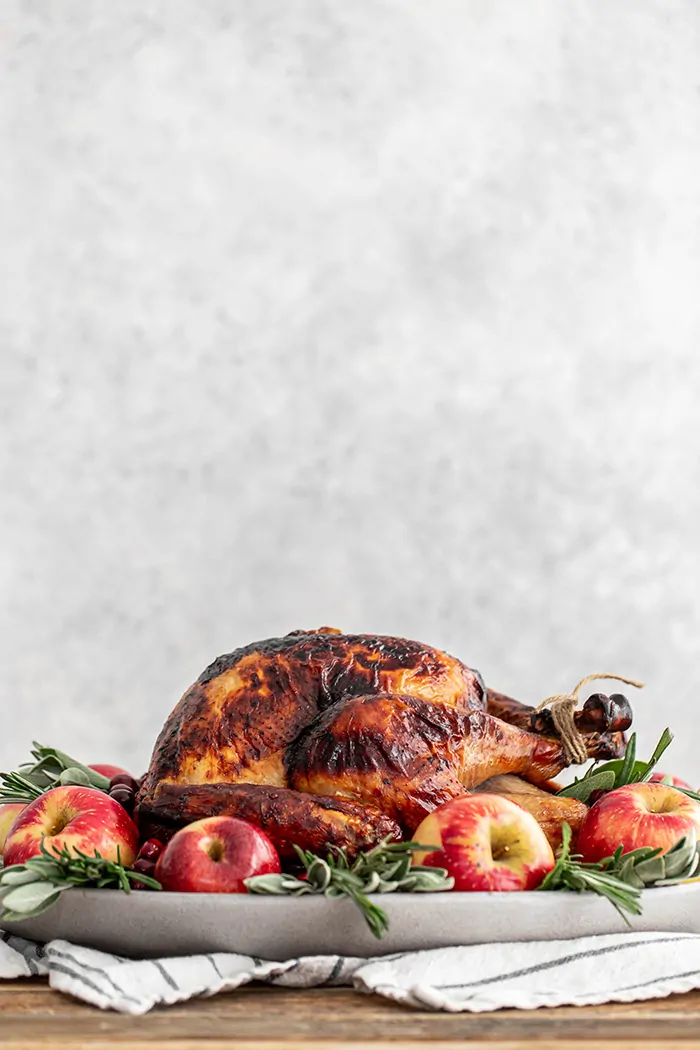 photo of a roasted apple cider turkey on a platter on a table