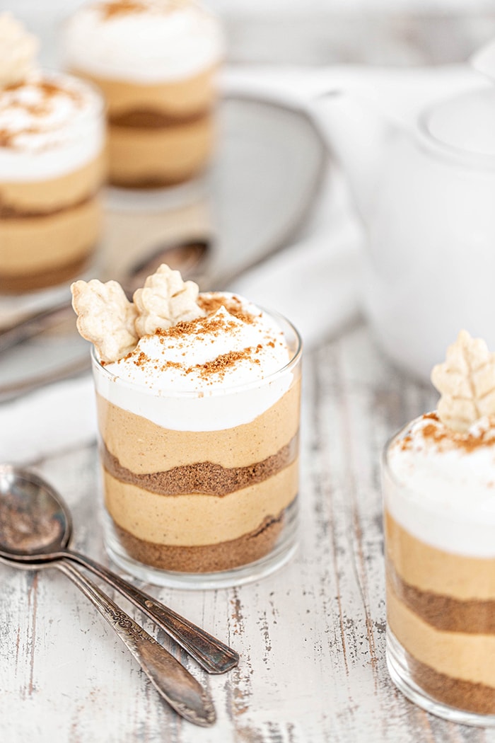 layered pumpkin dessert in a jar garnished with whipped cream and gingersnap