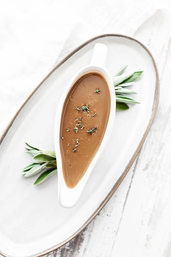 turkey gravy from drippings with sage in a white gravy boat